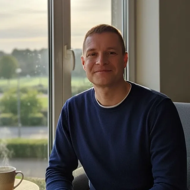 Bruno Vigné, fondateur de VIGNEDEV, souriant, assis près d’une fenêtre